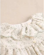 Vestido de bebé color crudo con estampado floral verde y volante en el cuello - Imagen 3
