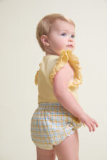 Camiseta sin mangas en color amarillo con detalle de volantes en los hombros y cierre trasero y braguita a juego con estampado de cuadros en tonos amarillo y celeste, decorada con lazos laterales y cintura elástica. - Imagen 3