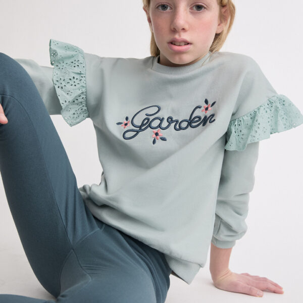 Sudadera con volantes bordados en los hombros y leggins ajustados