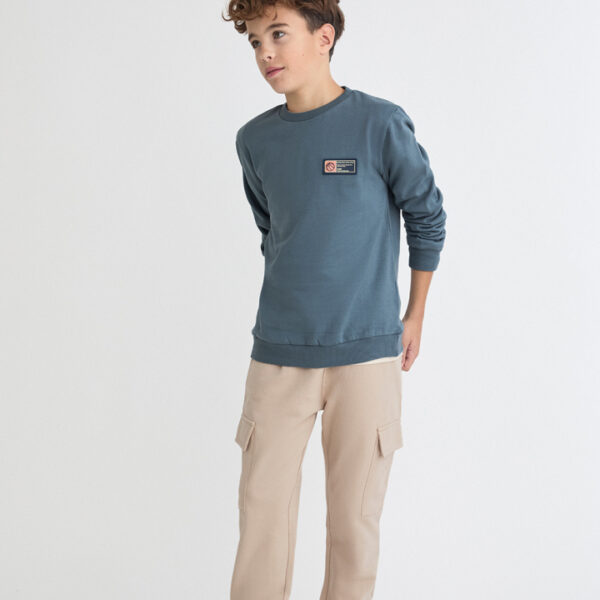 Sudadera con pequeño detalle frontal y pantalón tipo cargo con bolsillos laterales.