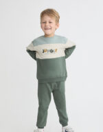 Conjunto de sudadera bicolor tonos verdes y crudo con texto y pantalón verde.