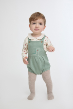 Camiseta cruda con estampado de dinosaurios y cuello bebé, combinada con ranita verde eucalipto acolchada y detalle frontal estampado.
