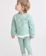 Sudadera verde con estampado de conejitos, volantes blancos en el bajo y lazo decorativo en el pecho. Leggings lisos a juego.