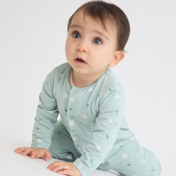 Pijama verde "sin pelo" con estampado de conejitos en contraste y cierre delantero con corchetes.