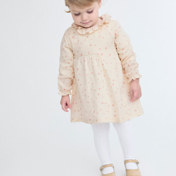 Vestido bebé niña beige estrellas. Tejido suave y ligero, delicado al tacto. Cuello volante y cierre cremallera espalda.