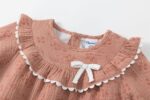 Vestido de manga larga con volante y lacito del tejido a tono, con forro interior goma elástica en la parte interior del puño. - Imagen 6