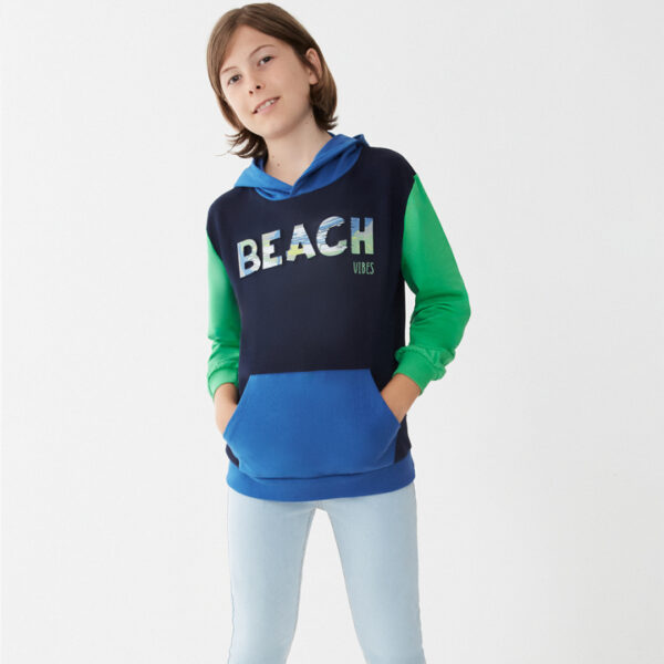 Sudadera azul marino con detalles en azul intenso y verde. Bolsillo canguro y estampado frontal.