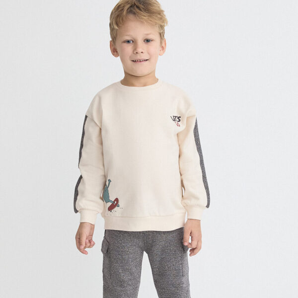 Sudadera cruda con dibujo de monstruo skater y pantalón gris vigoré con bolsillos cargo.